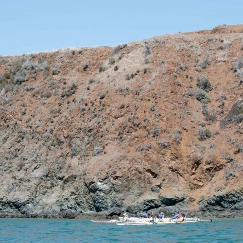 kayak past a rocky shore kayak past a rocky shore