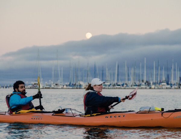 couple kayaks outside of San Francisco beneath a full moon